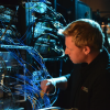 Tim Paule, a laboratory technician at Atom Computing, inspects the company’s custom-developed control systems that orchestrate their quantum platforms. 