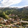 Aerial photo of a mountain town in summer with green trees and blue skies