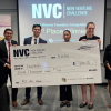 Team stands with giant prize check