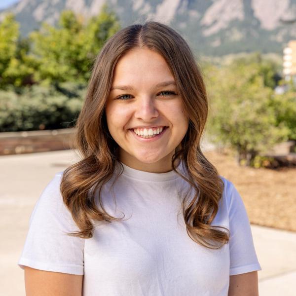 Alexa wearing a white shirt smiling in front of the flatirons