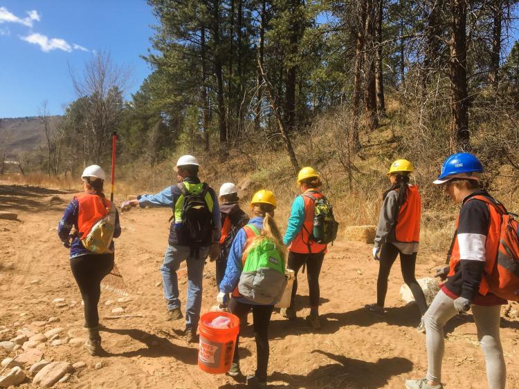 Students in bright vests working in the mountains