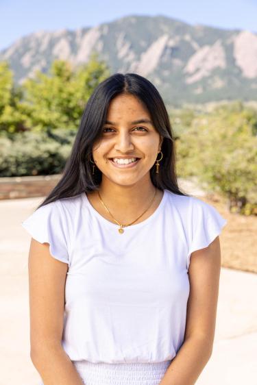 Vaishnavi wearing a white shirt smiling in front of the flatirons 