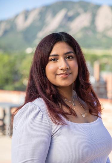 headshot of Sujei Perla Martinez wearing a white shirt in front of the Flatirons