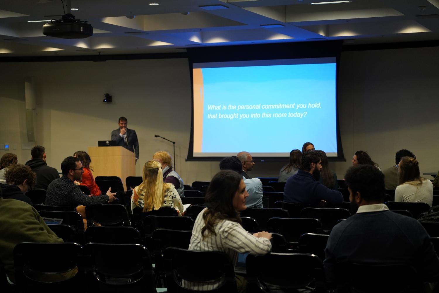 Man presents in front of a room of people