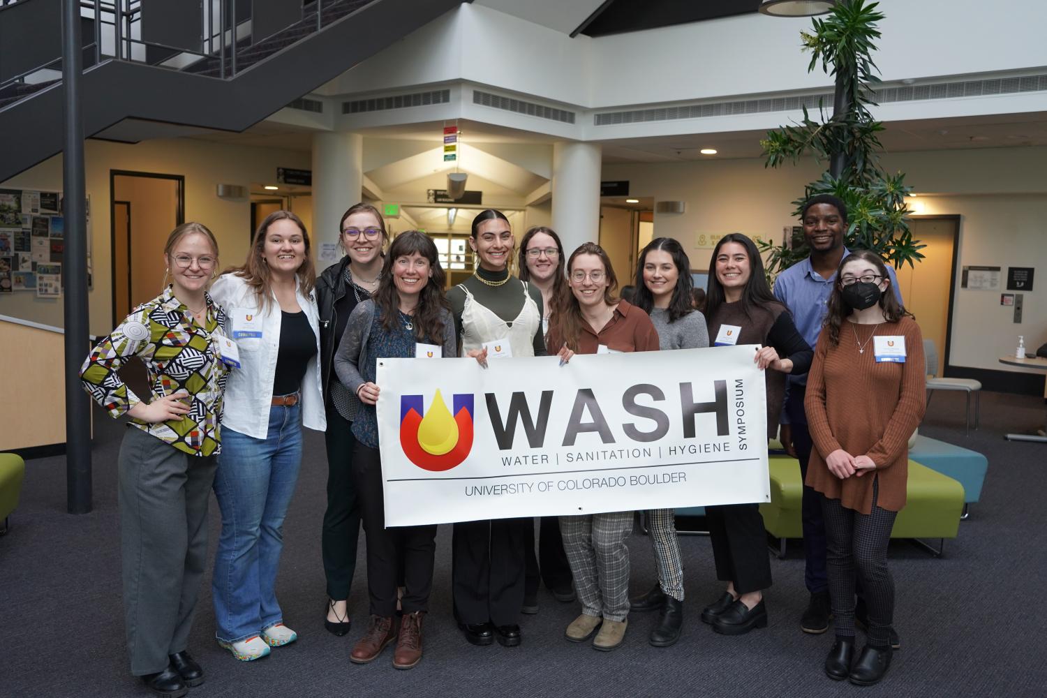 Group of people with CO WASH Symposium banner