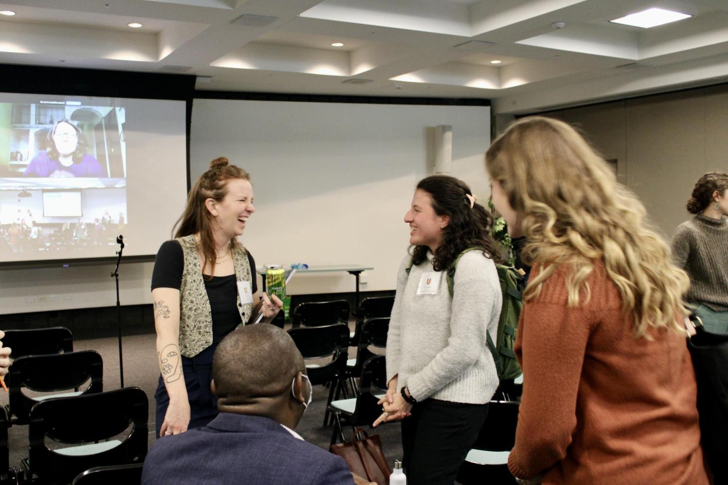 three female conference goers talking after a presentation